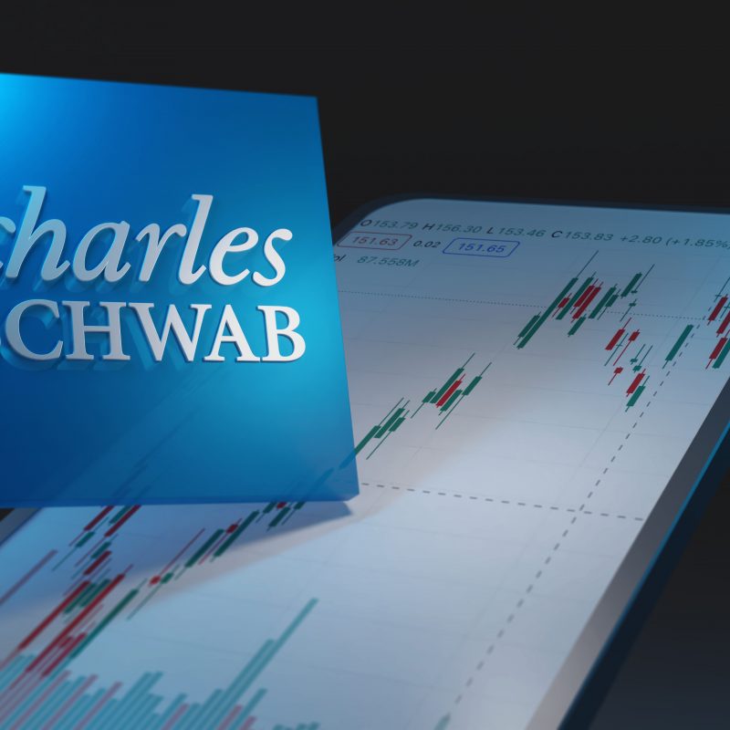 Charles,Schwab,Logo,And,Font,On,Dark,Background,With,Smartphone